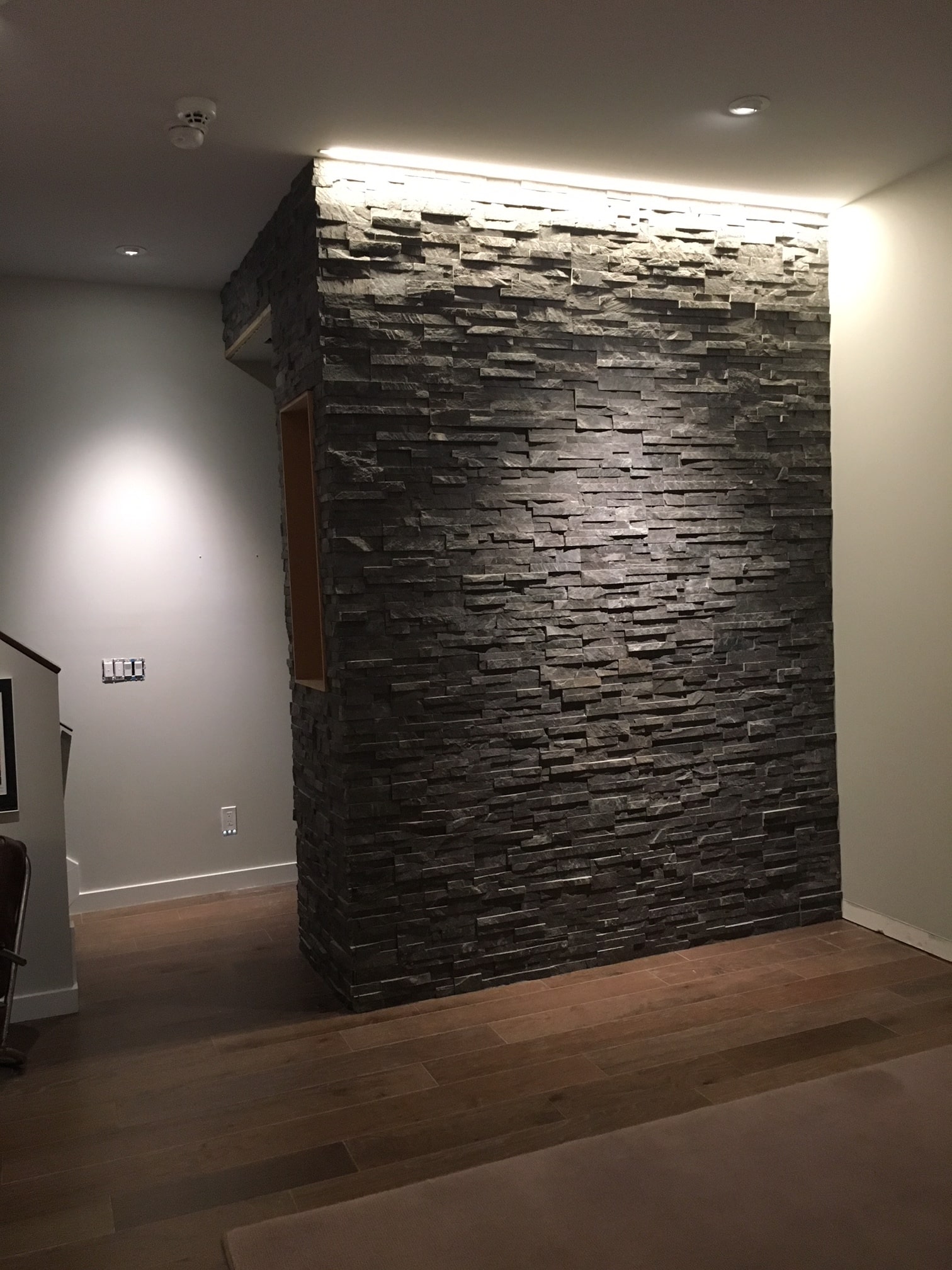Stacked Stone Entryway Feature Wall using Norstone Charcoal Rock Panels with recessed overhead lighting